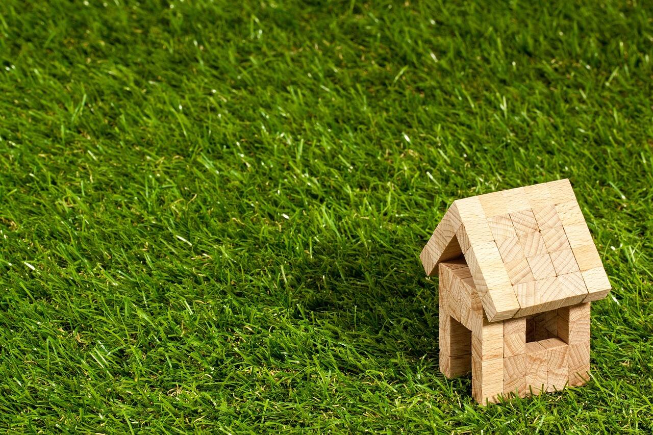 Lebensversicherung verkaufen für die Immobilienfinanzierung: Hausmodell mit Finanzierungsunterlagen